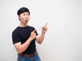 Young man feels amazed gesture point finger isolated photo