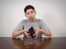 Poor man strain with no money show empty wallet at table photo