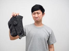 Asian man holding dirty socks feels smelly portrait photo