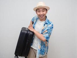el hombre viajero positivo sonríe feliz y lleva equipaje aislado foto