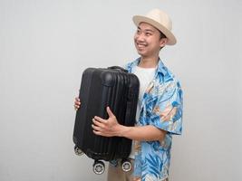 joven viajero hombre usar sombrero felices vacaciones llevar equipaje foto