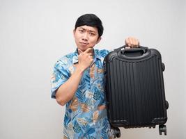 Young man holding laggage gesture thinking about vacation  isolated photo