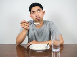 Depressed man looking at rice in hand feels bored eatting food photo