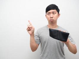 Poor man holding empty wallet sadness point finger at copy space photo