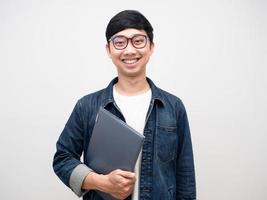 Young man wearing glasses holding laptop gentle smile isolated photo