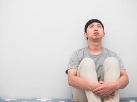 Man sit on the bed hugging knee thoughtful sadness emotion looking up photo