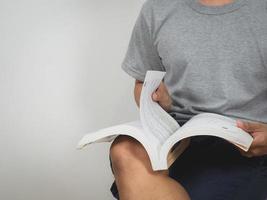 primer plano hombre sentarse leyendo libro de texto fondo blanco foto