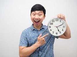 Positive man happy smile about finish working point finger at analog clock pm photo