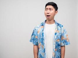 Young man beach shirt feels shocked looking at copy space photo