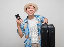 Traveler man satisfied happy with holiday hold mobile phone with luggage photo