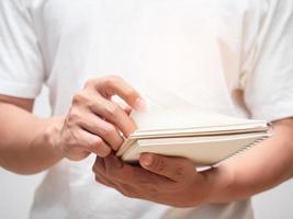 primer plano mano masculina sosteniendo el libro y abriendo la página del libro foto