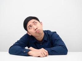 Man sitting at the table and feeling worried looking up at copy space white background photo