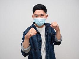 Man jeans shirt wear medical mask gesture punching for fighting with epidemic isolated photo