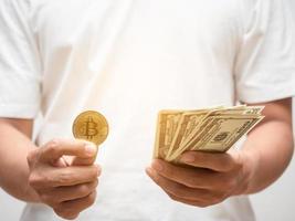 Closeup man hand holding golden bitcoin with dollar money photo