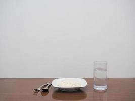 Dish of rice and cutlery with glass of water  on the table copy space photo