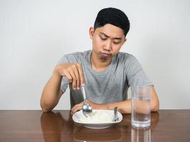 Asian man feels bored don't want to eat food photo