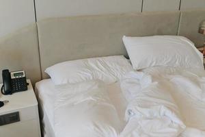 Unmade bedding sheets and pillow. Unmade messy bed after comfortable sleep concept photo