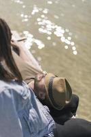 Picnic holiday concept. Beautiful couple having fun and relaxing by a lake. photo