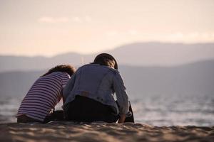 vista trasera de una feliz pareja romántica disfrutando de la hermosa puesta de sol en la playa. concepto de estilo de vida de jubilación de vacaciones de viaje foto