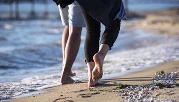 feliz pareja romántica disfrutando de un hermoso paseo al atardecer en la playa. concepto de estilo de vida de jubilación de vacaciones de viaje foto