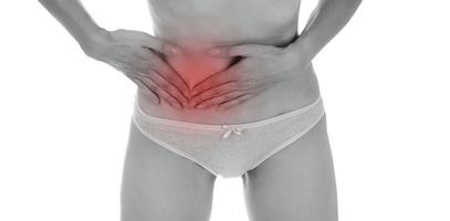 Young beautiful woman having painful stomachache on white background.Chronic gastritis. Abdomen bloating concept. photo