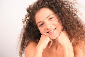 woman with curly hair and beautiful healthy face skin look at camera and posing. Beauty concept photo