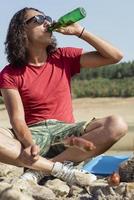 man on picnic drinking beer from unrecognized bottle photo