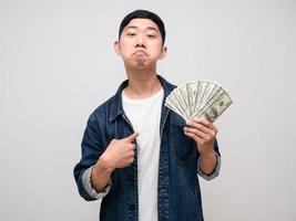 Young man jeabs shirt boast with money in hand point finger at himself isolated photo