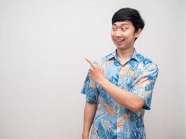 Young man beach shirt smile point finger at copy space photo