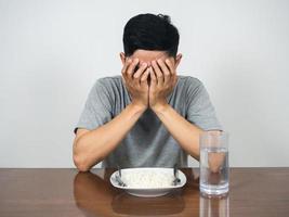 hombre deprimido cara cercana sentarse con la cena en la mesa foto