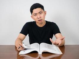 Young man feels strain with education sitting at table photo