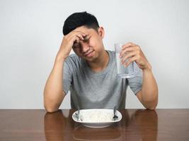 Asian man feels headache and sickness don't want to eat food on table photo