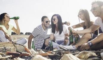 summer, holidays, vacation, music, happy people concept - group of friends with guitar having fun on the beach photo