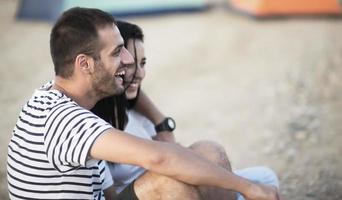 Picnic holiday concept. Beautiful couple having fun making BBQ on bonfire and relaxing by a lake. photo