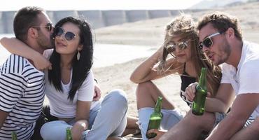 summer, holidays, vacation, music, happy people concept - group of friends with guitar having fun on the beach photo