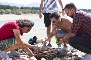 summer, holidays, vacation, music, happy people concept - group of friends with guitar having fun on the beach photo