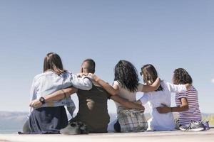 Group of friends having fun and relaxing by a lake. photo