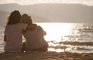 vista trasera de una feliz pareja romántica disfrutando de la hermosa puesta de sol en la playa. concepto de estilo de vida de jubilación de vacaciones de viaje foto