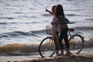 bicicleta de silueta y pareja de amor en las vacaciones al amanecer junto a un lago