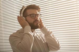 retrato de primer plano de un joven hipster con estilo disfrutando de su música favorita foto