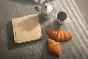 Breakfast with croissant and coffee and moka pot. Morning meal and breakfast concept. Top view. photo