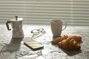 desayuno con croissant y café y cafetera moka. concepto de comida y desayuno por la mañana. foto