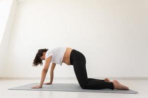 Purposeful pregnant woman exercises during yoga class and relaxes while sitting on a mat on the floor. Concept of physical and mental preparation of the body for childbirth. Place for text photo