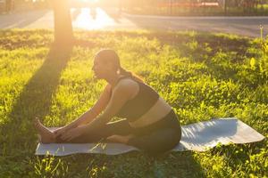 mujer embarazada haciendo yoga en la naturaleza al aire libre. estilo de vida saludable, esperando bebé y concepto de maternidad. foto