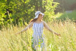 Woman walking in a field in summer sunny day. photo