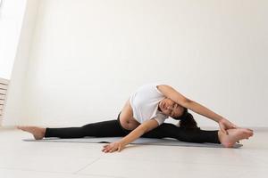 Purposeful pregnant woman exercises during yoga class and relaxes while sitting on a mat on the floor. Concept of physical and mental preparation of the body for childbirth. Place for text photo