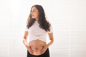 mujer embarazada tocándose el vientre, copie el espacio. licencia por embarazo y maternidad foto