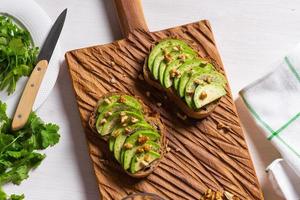 Avocado toasts for breakfast or lunch with rye bread, pumpkin seeds. Vegetarian food top view photo