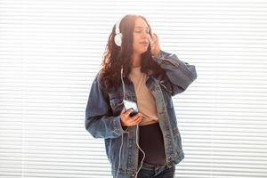 hermosa joven embarazada pacífica escucha música clásica agradable con smartphone y auriculares. concepto de actitud positiva antes del parto foto