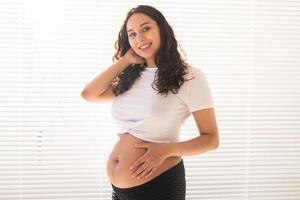 mujer embarazada tocándose el vientre, copie el espacio. licencia por embarazo y maternidad foto